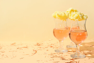Glasses with delicious cotton candy cocktail and confetti on color background