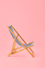 Beach deck chair on pink background