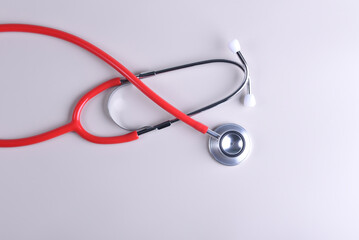 Red beautiful therapist's stethoscope on a white background
