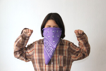 10-year-old Hispanic girl wears a purple headscarf representing the struggle for feminism and...