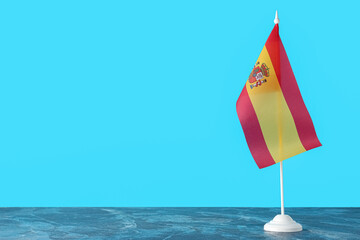 Flag of Spain on table against color background