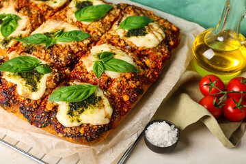 Delicious Italian pie with mozzarella and pesto sauce on table, closeup