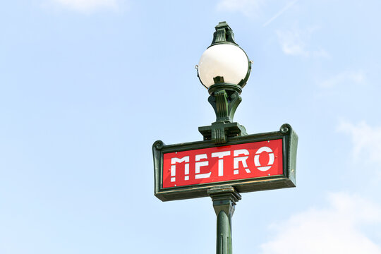 Illustration picture shows a sign with the subway logo (red symbol) in front of a parisian metro (metropolitain) station with a blue sky in the background during a summer day in Paris, France.
