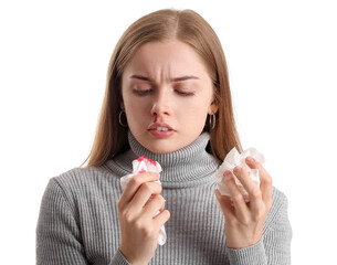 Young woman with nosebleed and tissue on white background, closeup