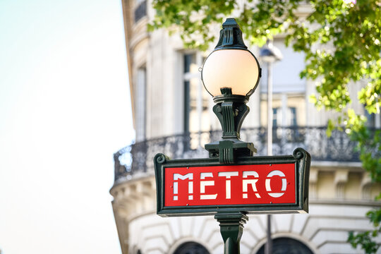 Illustration picture shows a sign with the subway logo (red symbol) in front of a parisian metro (metropolitain) station during a summer day in Paris, France.