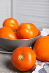 Many ripe yellow tomatoes on grey table, closeup