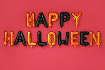 Text HAPPY HALLOWEEN made of balloons on red wall