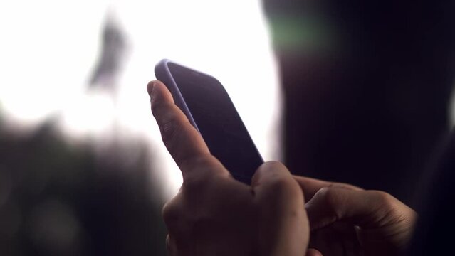 close-up of the hands of a male model typing a message on a smartphone