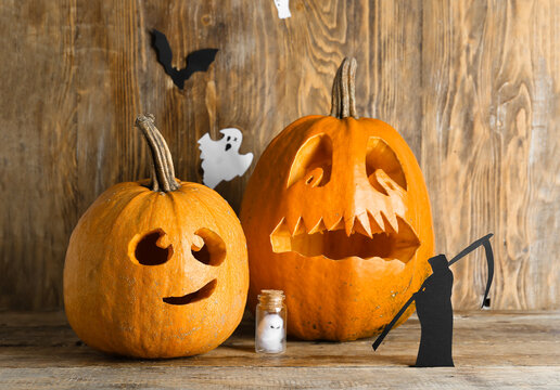 Jack-O-Lantern pumpkins on wooden background