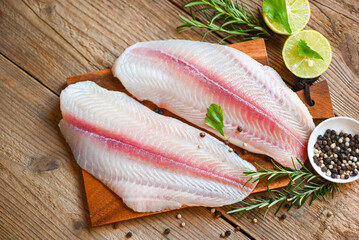 fish fillet on wooden board with ingredients for cooking, meat dolly fish tilapia striped catfish,...