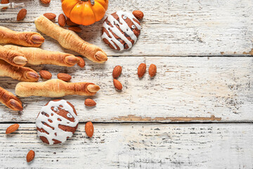 Halloween cookies with almond nuts on white wooden background