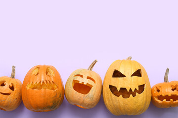 Carved Halloween pumpkins on color background, top view