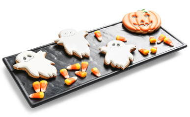 Board with Halloween cookies and candy corns on white background