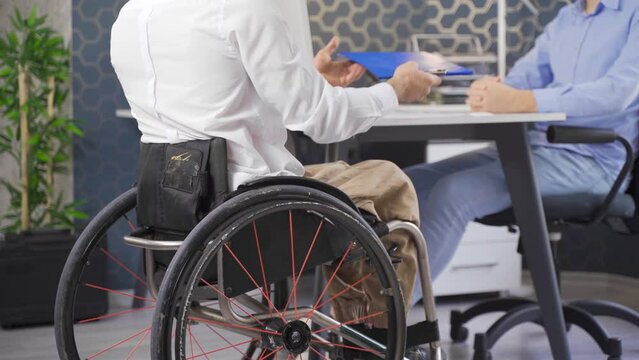 Disabled youth applying for a job. Disabled young man who wants to work.
Disabled youth in a wheelchair came to the office to apply for a job.
