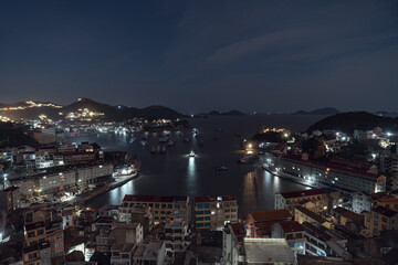 Naklejka premium Seaside port with residental houses around at night, in Taizhou, Zhejiang.