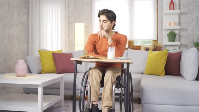 Disabled teenager is happy at home.
The young disabled person, who is at home with his wheelchair, is eating.
