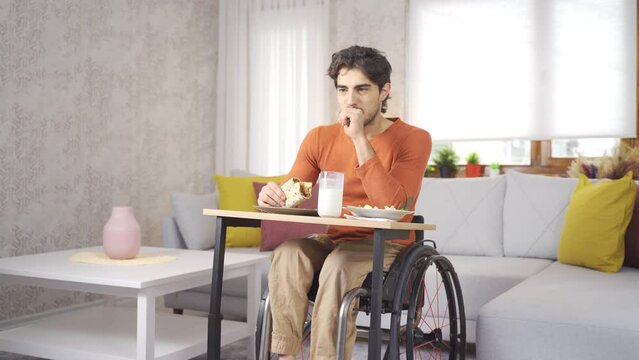 Young person with physical disability who eats.
Disabled young man eating in a wheelchair.
