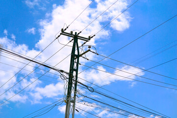 Lightpole with blue sky and white clouds.