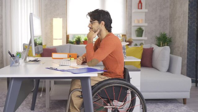 Frustrated disabled businessman working in his home office.
Disabled teenager sitting in a wheelchair works at his desk and is nervous.
