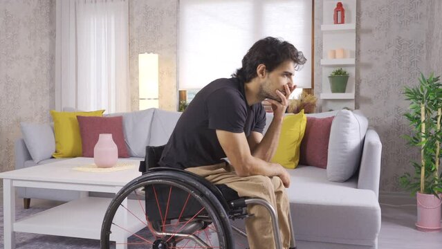 Sad disabled young man sitting in his wheelchair.
Sad disabled young man is unhappy.
