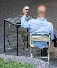 Rear view of a man enjoying a glass of beer on a table in Madrid city center
