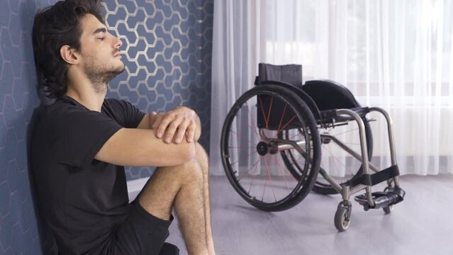 Unhappy and sluggish disabled man.
Disabled man alone leans against a wall and thinks.
