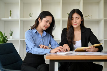 Attractive Asian female accountants working together in the office