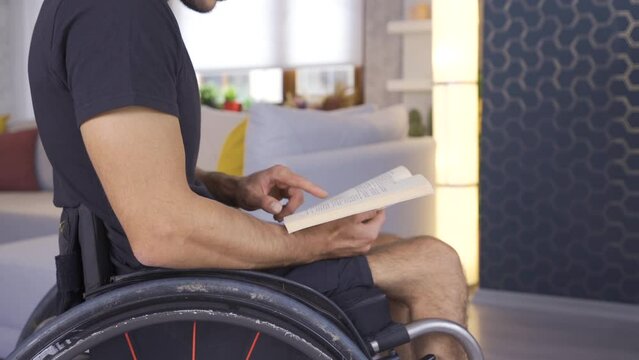Disabled person reading a book in a wheelchair.
Disabled young man reading a book at home.
