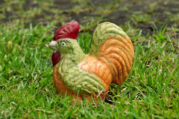 Colorful chicken piggy bank on green grass