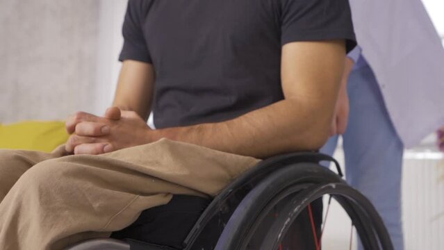 Doctor in White Medical Suit is driving wheelchair of Disabled Person. Slow Motion.
Disabled man in wheelchair in slow motion.
