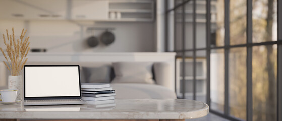 Laptop mockup on marble tabletop over blurred modern living room in the background