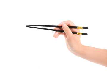 female hand holds black chopsticks isolated on white background.