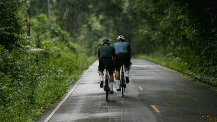 Naklejka premium Groups of cyclists riding road bikes in the morning are climbing.
