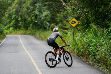Obraz premium Cyclists riding road bikes in the morning are climbing.
