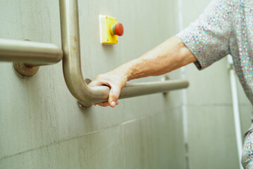 Asian elderly old woman patient use toilet support rail in bathroom, handrail safety grab bar,...