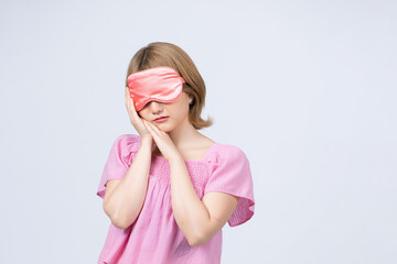 Young woman with sleep mask isolated on white background