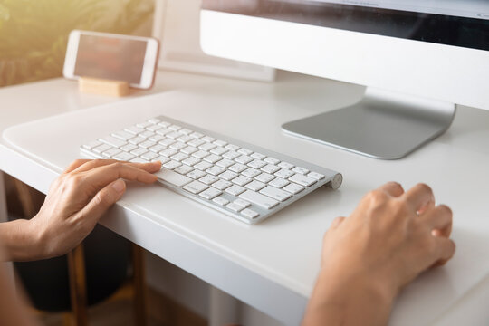 Close-up hand of Asian woman working office worker typing on keyboard at home office