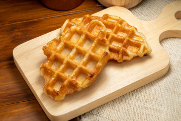 Waffles with butter and honey on a wooden tray ready to serve.