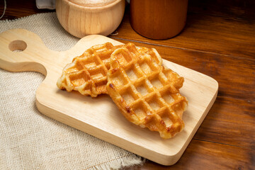 Waffles with butter and honey on a wooden tray ready to serve.