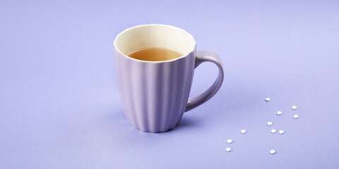 A cup of tea with sweetener.