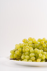 Delicious green grapes on a white plate.