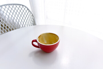 top view of empty cup red of coffee on table white in cafe morning, beautyful light. concept of dirty empty coffee cup after drink.