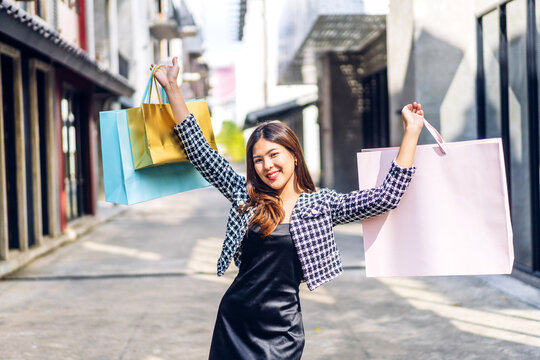Portrait of smiling beauty asian fashion happy woman relax and enjoy shopping time summer sale walk and holding shopping colorful bag to buy something purchases at store