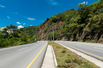 Double carriageway west of the department of Antioquia, Colombia. Landscapes with dual carriageway, mountains and blue sky - obrazy, fototapety, plakaty