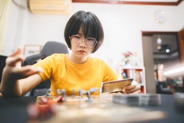 Young adult asian woman enjoying role playing tabletop and board games