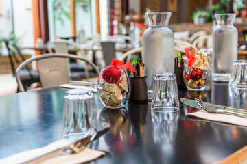 A table set up for Christmas dinner with place settings, cutlery, glasses and Christmas decorations