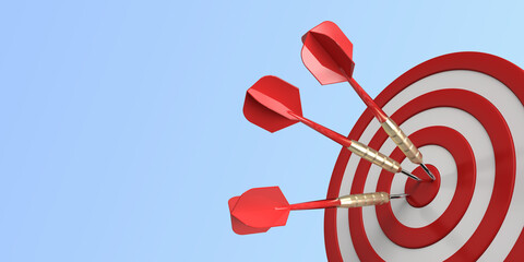 Three darts hitting a red target on the center on blue background with copy space.  © Jaromír