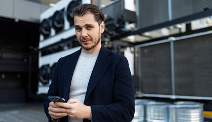 industrial refrigeration installation engineer with a serious face holding a mobile phone, concept of professional maintenance of industrial refrigeration systems