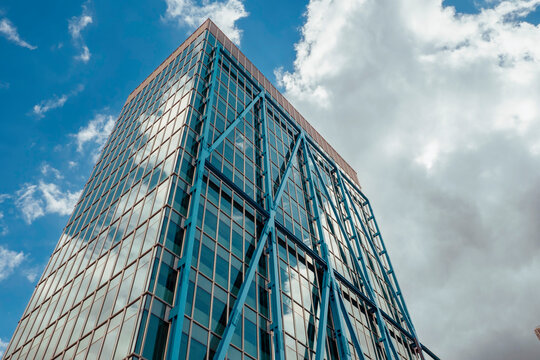 Dublin, Ireland - 25.08.2022: The Exo Building in Dockland area. Metal and glass building reflecting blue cloudy sky.