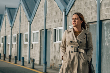 woman in trench coat walking down the street in winter